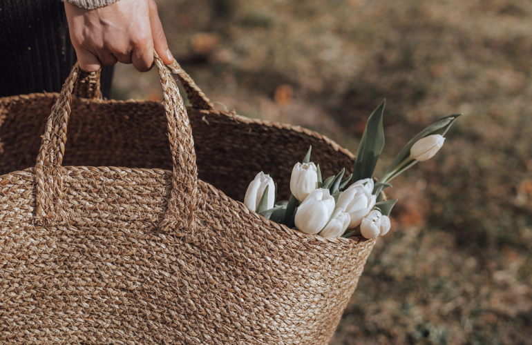 Person collecting flowers in basket