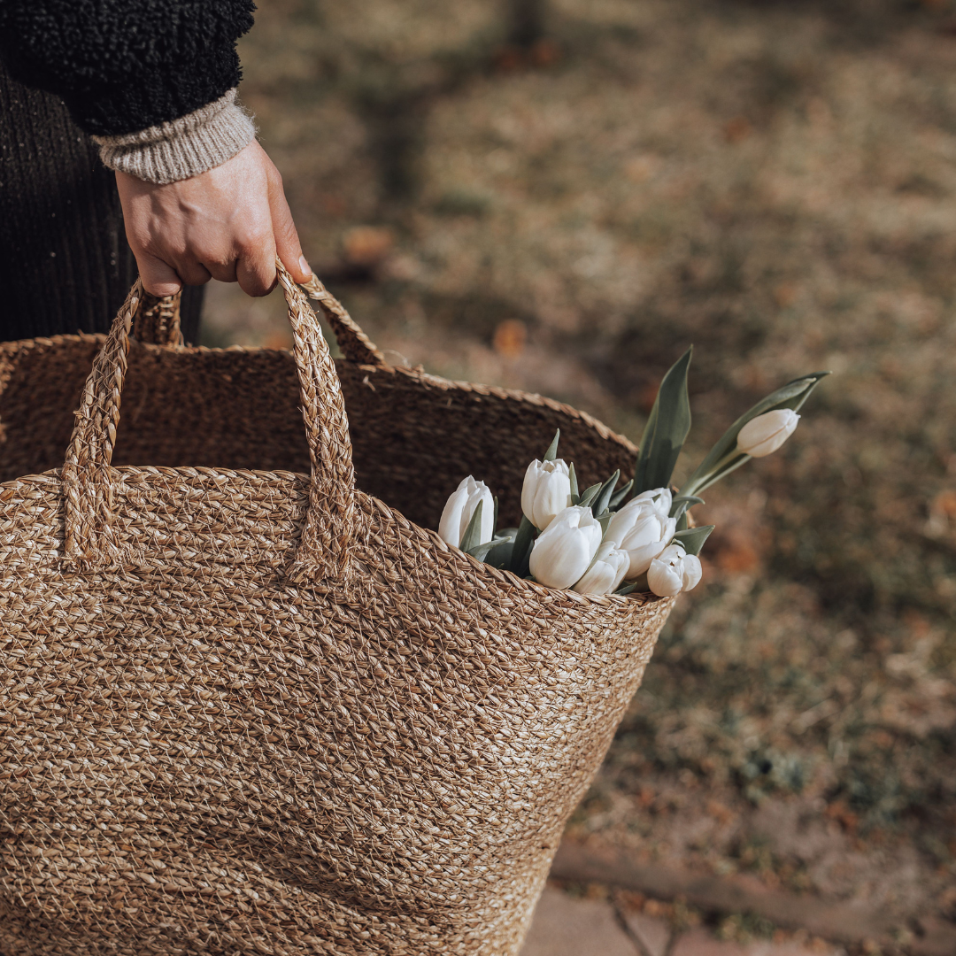 Person collecting flowers in basket